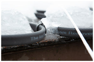 Closeup of The Ice Dam Remover heating cable melting an ice dam on a roof.